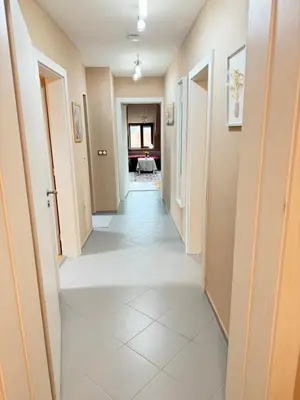 a corridor of a hallway with white tile floors at New cozy apartment with undefloor heating 86m2 in Sofia