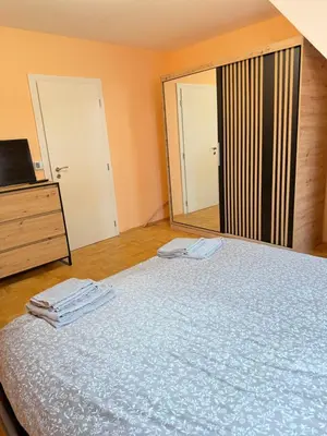 a bedroom with a bed and a dresser and a mirror at New cozy apartment with undefloor heating 86m2 in Sofia