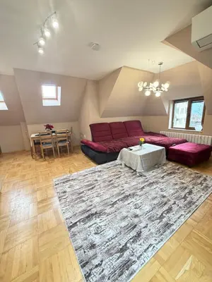 a living room with a red couch and a table at New cozy apartment with undefloor heating 86m2 in Sofia