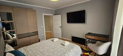 a bedroom with a bed and a television on the wall at By The Pool Apartments #8 in Velingrad