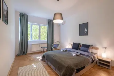 a bedroom with a bed and a large window at Beautiful Bright and Spacious Central Apt in Sofia