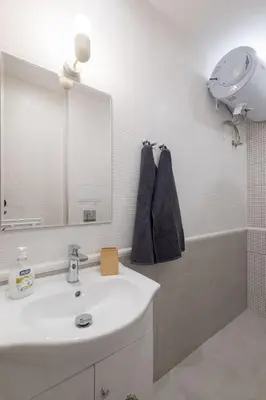 a bathroom with a sink and a mirror and a tub at Beautiful Bright and Spacious Central Apt in Sofia