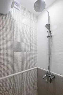 a shower with a shower head in a bathroom at Beautiful Bright and Spacious Central Apt in Sofia