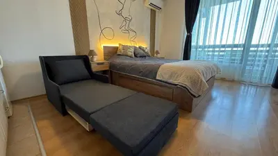 a bedroom with a bed and a chair and a window at Aspen Golf Resort Studio E206 in Bansko