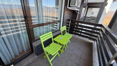 two green chairs and a table on a balcony at Aspen Golf Resort Studio E206 in Bansko