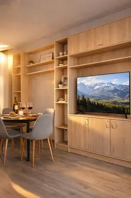 a dining room with a television and a table and chairs at Mountain View Escape - Cozy Apt with Private Parking in Sofia