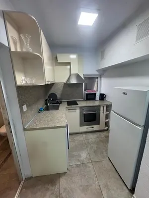 a kitchen with white cabinets and a white refrigerator at Berta Gardens 2 in Sandanski