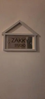 a light on a wall with a zalky studio sign at ZAKKY STUDIO Cozy Apartment to the City Center and International Fair in Plovdiv