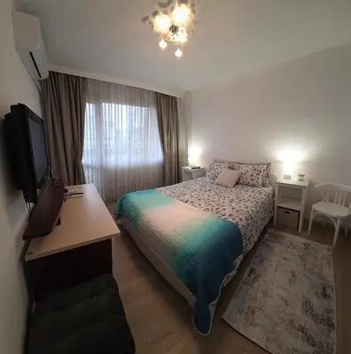 a bedroom with a bed and a desk and a television at ZAKKY STUDIO Cozy Apartment to the City Center and International Fair in Plovdiv