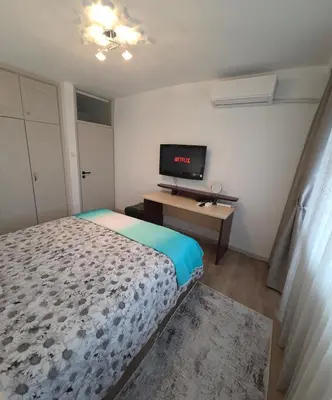 a small bedroom with a bed and a television at ZAKKY STUDIO Cozy Apartment to the City Center and International Fair in Plovdiv