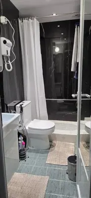 a bathroom with a white toilet and a shower at ZAKKY STUDIO Cozy Apartment to the City Center and International Fair in Plovdiv