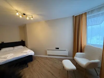 a bedroom with a bed and a chair and a window at Pamporovo Living Cozy Mountain Home in Chepelare
