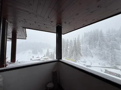 a window in a room with a snow covered mountain at Pamporovo Living Cozy Mountain Home in Chepelare