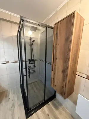 a shower with a wooden cabinet in a room at Pamporovo Living Cozy Mountain Home in Chepelare