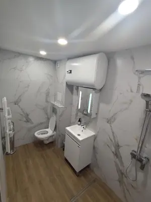 a white bathroom with a toilet and a sink at Martin's Apartment in Bansko