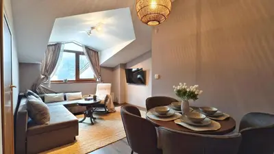 a living room with a table and a couch at Cozy Stylish 2-bedroom apt near ski road, 5min to Gondola & bars in Bansko