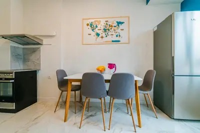 a kitchen with a table and chairs and a refrigerator at Central Apartment near NDK in Sofia