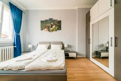 a bedroom with a bed and a blue curtain at Central Apartment near NDK in Sofia