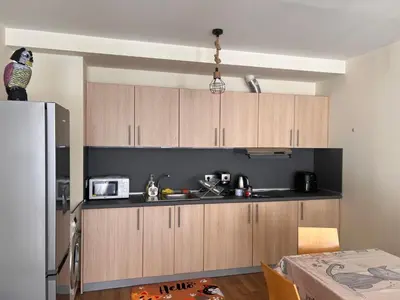 a kitchen with wooden cabinets and a microwave at Lyra Forest Apartment in Borovets