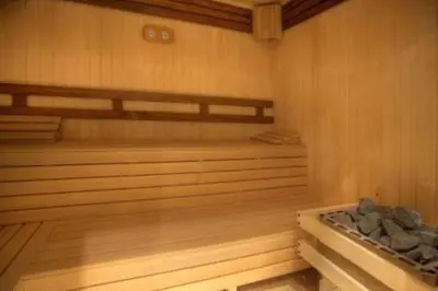 an empty sauna with wooden floors and wooden shelves at Lyra Forest Apartment in Borovets