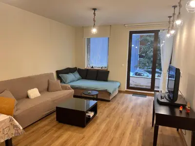 a living room with a couch and a table at Lyra Forest Apartment in Borovets