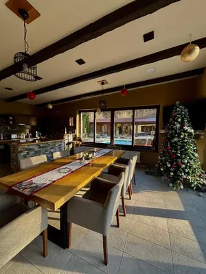 a dining room with a long table and a christmas tree at Къща за гости Гергана in Ribarica