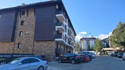 a group of cars parked next to a building at Aurora Apartment in Bansko