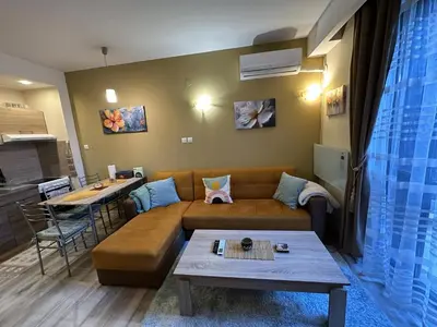 a living room with a couch and a table at Aurora Apartment in Bansko
