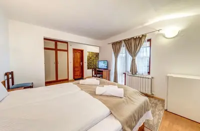 a large bedroom with two beds and a television at Комплекс Райковски Ливади in Pamporovo