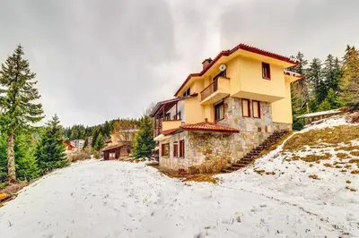 a house on a snow covered road in front at Комплекс Райковски Ливади in Pamporovo
