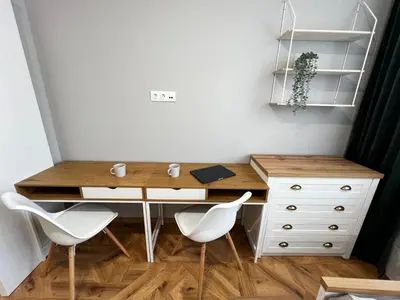 a desk with white chairs and a wooden table at Monaco 100 Sq M 3BDR Apt on Oborishte street with WiFi in Sofia