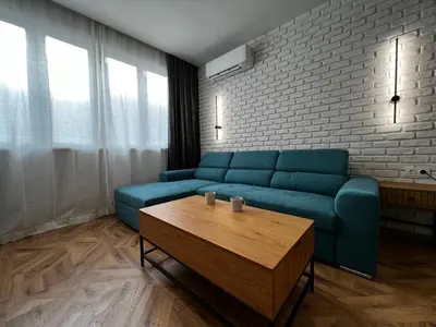 a living room with a blue couch and a coffee table at Monaco 100 Sq M 3BDR Apt on Oborishte street with WiFi in Sofia