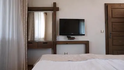 a bedroom with a bed and a tv on the wall at Комплекс Белите скали in Gaytaninovo