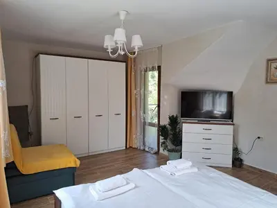a bedroom with a bed and a tv and a couch at River Garden in Beli Osŭm