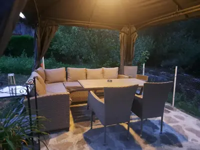 a table and chairs under a tent with a couch at River Garden in Beli Osŭm