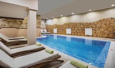 a pool in a hotel with lounge chairs and a swimming pool at Private Studio in Royal Park in Bansko