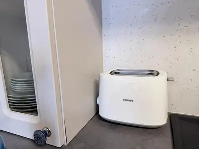 a toaster sitting next to a cabinet with plates at New top center cozy 3 bedroom apartment in Sofia