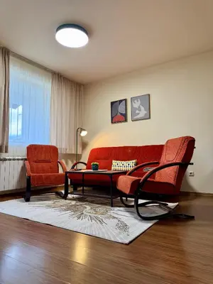 a living room with two red chairs and a couch at Gino's place 2 Home2Host in Bansko