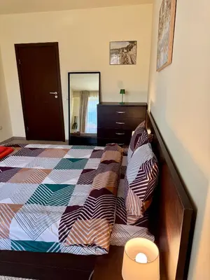 a bedroom with a bed and a dresser and a mirror at Gino's place 2 Home2Host in Bansko