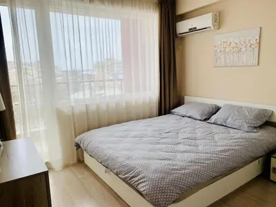 a small bedroom with a bed with a window at Old Town Prime Apartment & Parking in Plovdiv