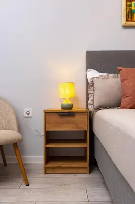 a table with a lamp on it next to a bed at Gorgeous central Yanevi 2 BR & parking in Plovdiv