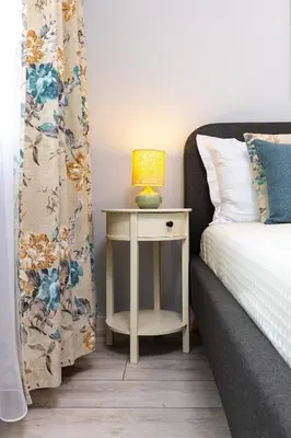 a bedside table with a lamp on it next to a bed at Gorgeous central Yanevi 2 BR & parking in Plovdiv