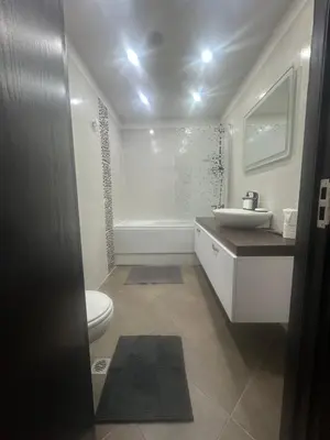a white bathroom with a sink and a toilet at Prime Mountain View Bansko in Bansko