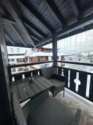 a table and chairs on a balcony with a view of the water at Prime Mountain View Bansko in Bansko