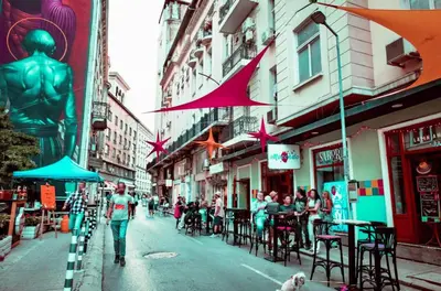 a group of people sitting at tables on a city street at 2BR Apt - Parking - Central - 1st floor - ACs in Sofia