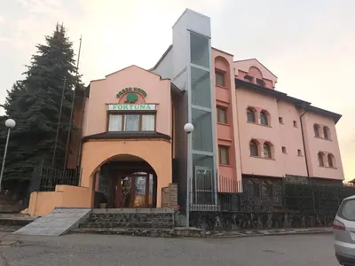 a large pink building with a door in front at Green Hotel Fortuna in Sapareva Banya