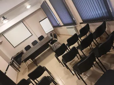 an empty lecture room with chairs and a screen at Green Hotel Fortuna in Sapareva Banya