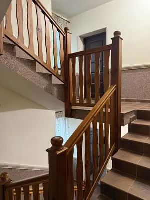 a staircase in a home with wooden railings at Къща за гости GREEN HILLS in Beli Osŭm