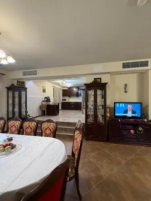 a living room with a table and a flat screen tv at Къща за гости GREEN HILLS in Beli Osŭm