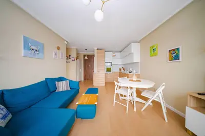a living room with a blue couch and a table at Sunny 1BR with Balcony in Sofia